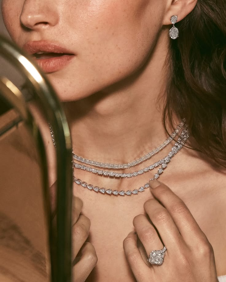 Layered diamond neckpieces worn at a mirror